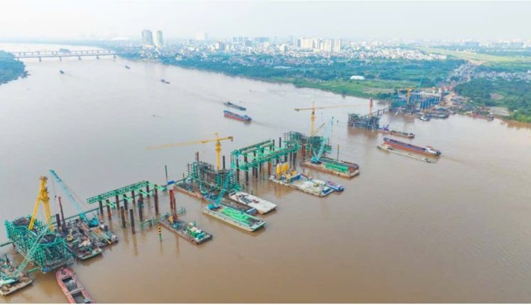 Công trường cầu Trần Hưng Đạo nhìn từ trên cao, các trụ cầu và cần cẩu giữa sông Hồng